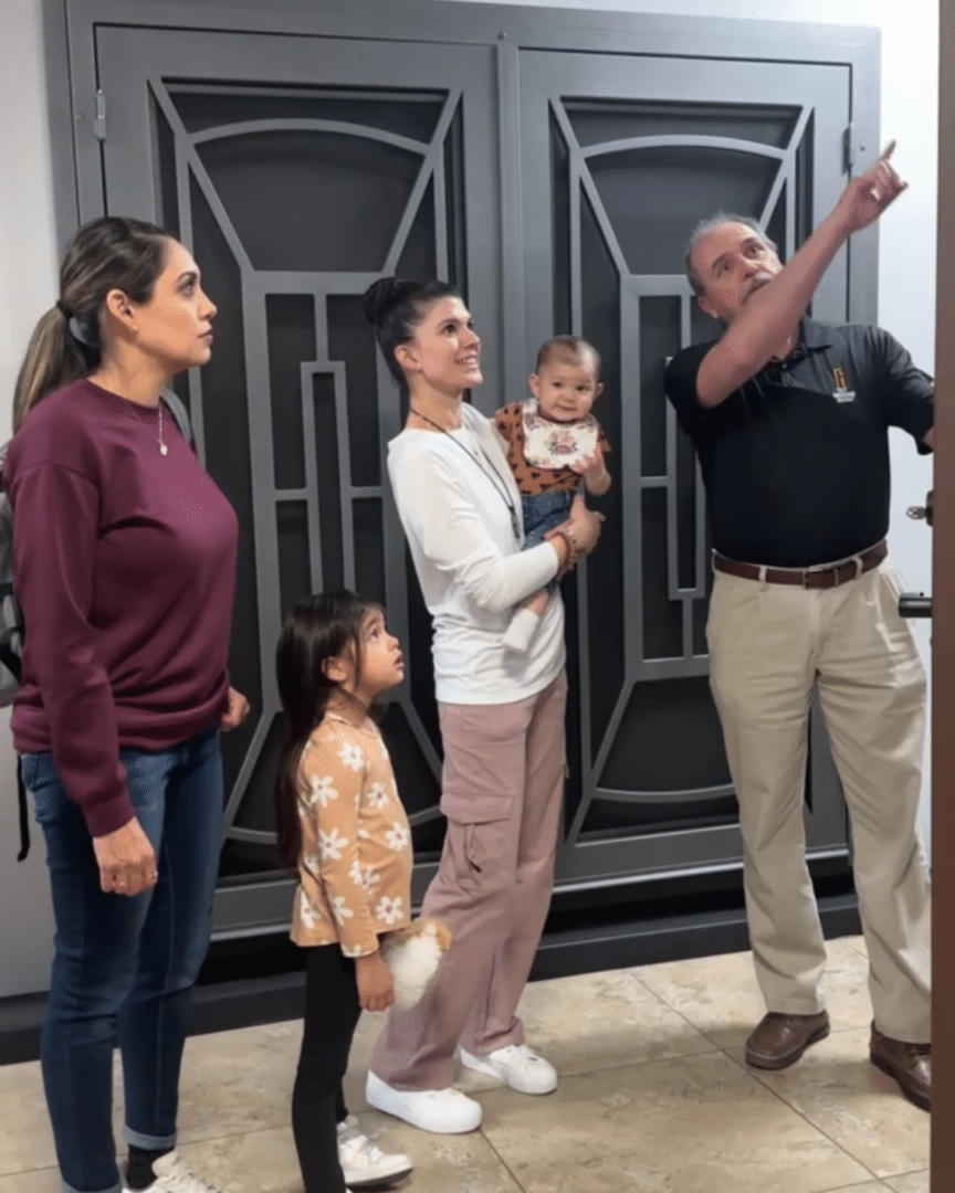 A First Impression Ironworks Design Specialist  showing Neg and Mel different iron door features, in the showroom