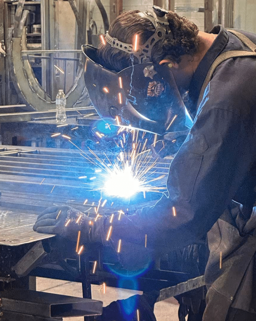 Welder working on a First Impression Ironworks door