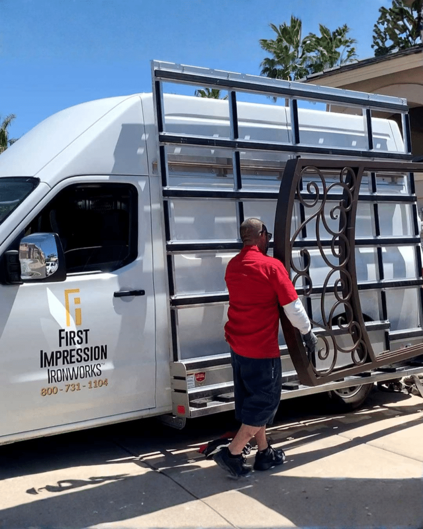 First Impression Ironworks installers carrying a large iron entry door