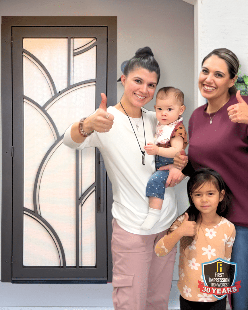 Neg and Mel posing with their children in front of their First Impression Ironworks security door